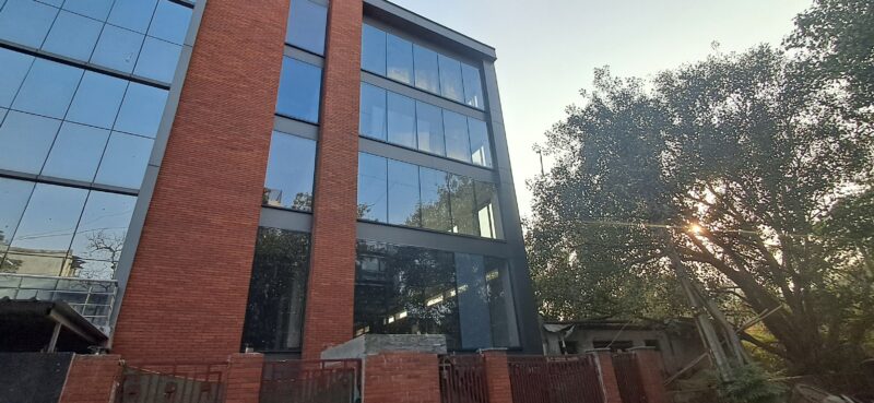 Modern commercial building exterior with easy metro transit access in Okhla Phase 3.
