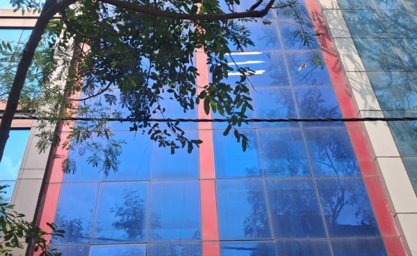 Industrial DDA shed commercial building exterior with wide compound entry in Okhla Phase 2.
