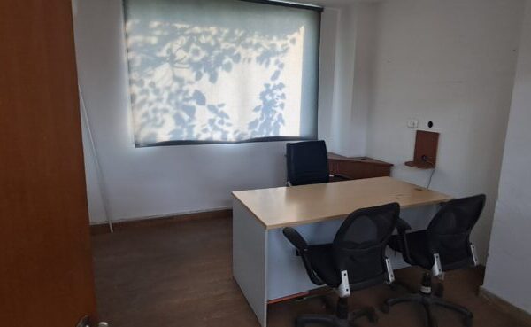 Glass-partitioned private executive cabin and meeting nook inside an office rental in Okhla Phase 3 Delhi.