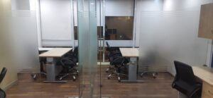 Private glass-partitioned executive cabin with manager desk inside a furnished office on rent in Okhla Phase 2.