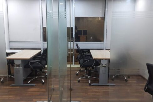 Private glass-partitioned executive cabin with manager desk inside a furnished office on rent in Okhla Phase 2.