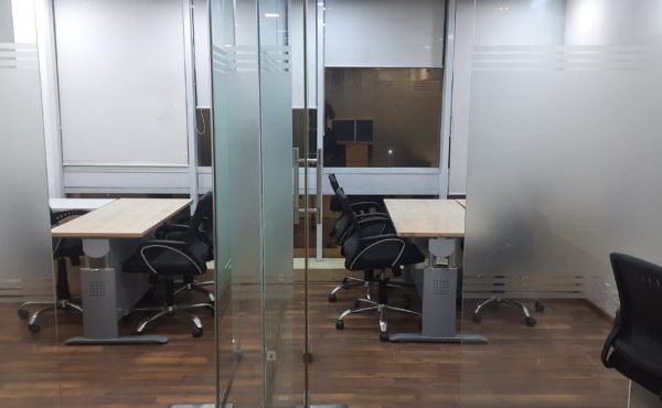 Private glass-partitioned executive cabin with manager desk inside a furnished office on rent in Okhla Phase 2.