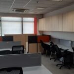 Modern reception area of a brand-new furnished office space for rent in Okhla Phase 2 with corporate branding wall and seating.