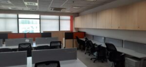Modern reception area of a brand-new furnished office space for rent in Okhla Phase 2 with corporate branding wall and seating.