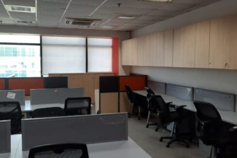 Modern reception area of a brand-new furnished office space for rent in Okhla Phase 2 with corporate branding wall and seating.