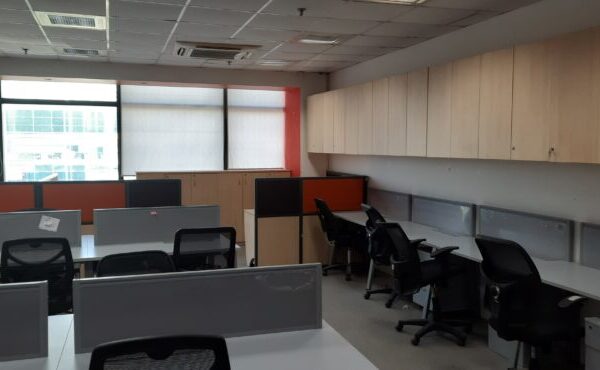 Modern reception area of a brand-new furnished office space for rent in Okhla Phase 2 with corporate branding wall and seating.