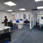 Elegant corporate office interior with modern workstation desks and glass cabins in DLF Prime Towers Okhla.