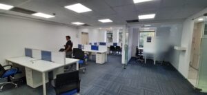 Elegant corporate office interior with modern workstation desks and glass cabins in DLF Prime Towers Okhla.