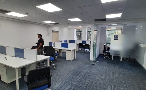 Elegant corporate office interior with modern workstation desks and glass cabins in DLF Prime Towers Okhla.