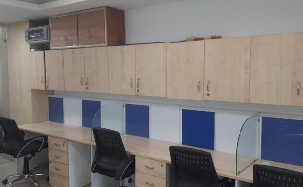 Rows of ergonomic open workstations with structured cable management in an Okhla Phase 2 rental office.
