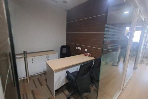 Glass-partitioned private manager cabin with executive desk inside a furnished office lease unit in Okhla.