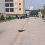 Gated commercial parking area with 24/7 security guard monitoring in Okhla Phase 2.